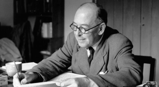 C. S. Lewis à son bureau en train d'écrire